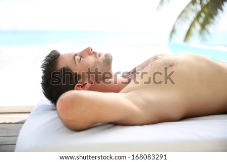 Man relaxing on massage bed outside