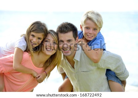 Cheerful parents holding kids on their back