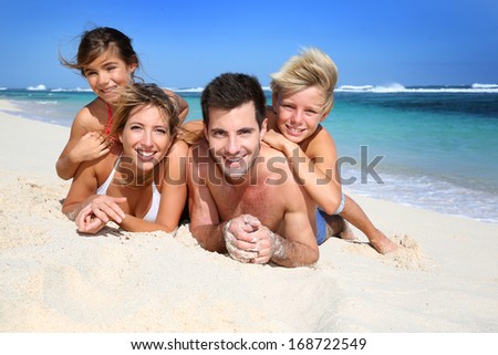 Portrait Of Happy Family Laying On The Beach