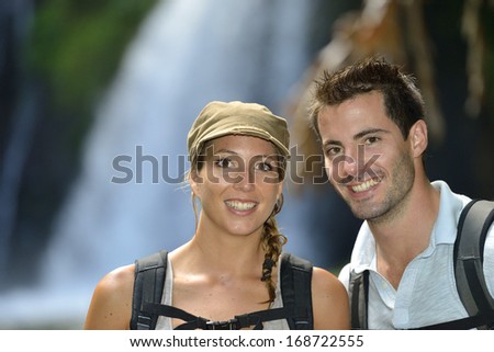 Trekkers reaching waterfall in natural landscape