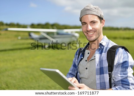 Adventurer using digital tablet in aerodrome