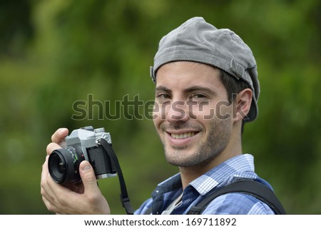 Young man taking picture with vintage camera