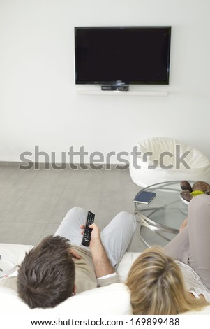 Rear view of couple watching TV