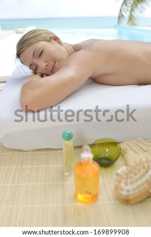 Woman relaxing on massage bed outside