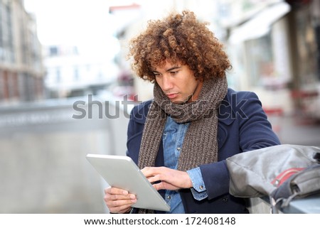 Attractive man using digital tablet in town