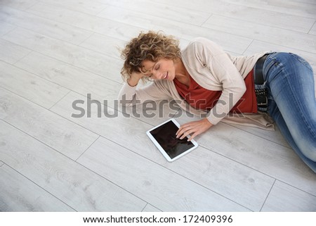 Woman laying on the floor with digital tablet