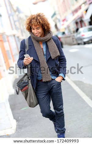Trendy smiling man talking on phone in the street