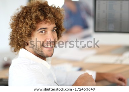 Portrait of cheerful man working on desktop