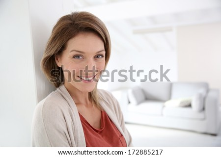 Middle-aged woman standing in modern home