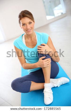 Beautiful fitness woman sitting in gym