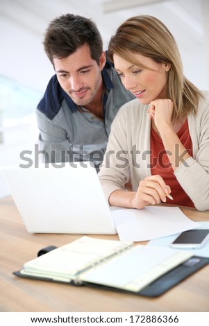 Couple at home checking accounts on internet