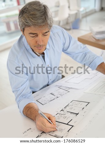 Architect working on blueprint in office