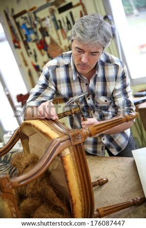 Craftsman Repairing Antique Armchair In Workshop