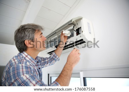 Repairman fixing air conditioner unit