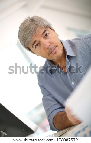 Senior businessman sitting in front of desktop