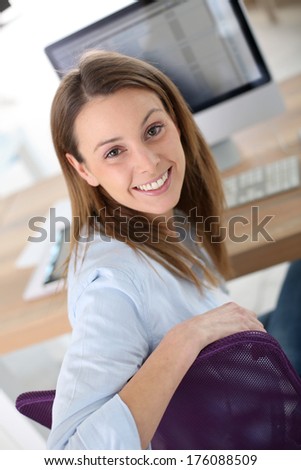 Smiling woman in office sitting at desktop