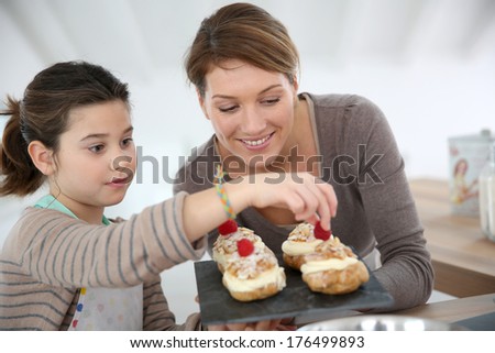 Mother and daughter preparing cream puffs