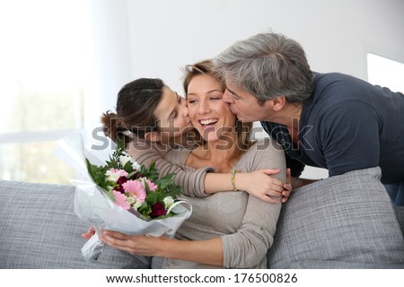 Family celebrating mother\'s day with bunch of flowers
