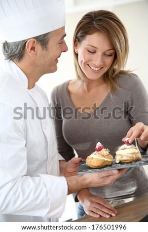 Pastry cook having woman tasting pastries