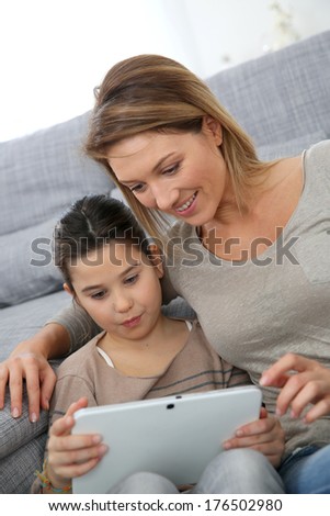 Mother and daughter playing with digital tablet