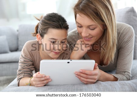 Mother And Daughter Playing With Digital Tablet