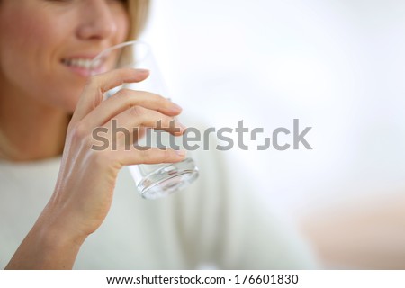 Closeup on glass of water held by woman\'s hand