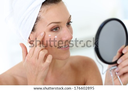Middle-aged woman in bathroom looking at mirror