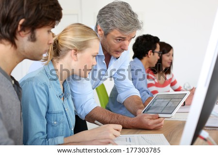 Teacher using digital tablet in school class