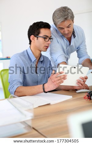 Young man in business training school with teacher