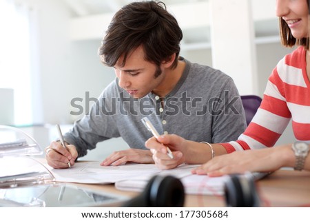 Student writing an exam in class
