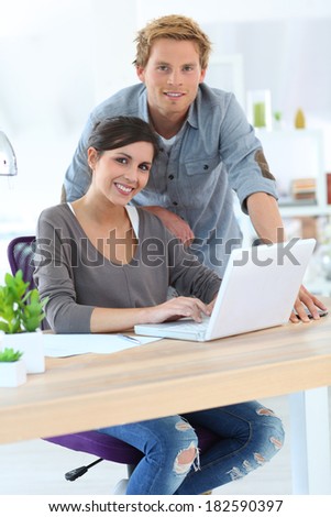 Young people in office working on laptop