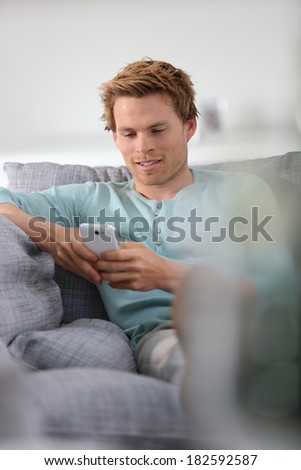 Young man in sofa with smartphone