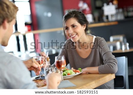 Young woman in restaurant eating lunch with boyfriend