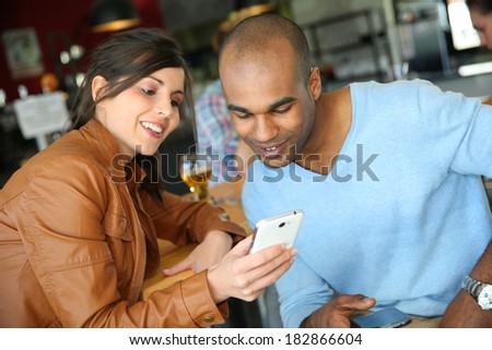 Young people in coffee shop using smartphones