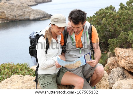 Couple of hikers reading orientation map