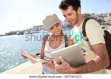 Couple of tourists looking at city map of Ibiza
