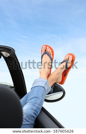 Closeup of feet with flip flops showing by car window