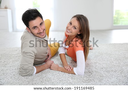 Couple laying on carpet of brand new renovated flat
