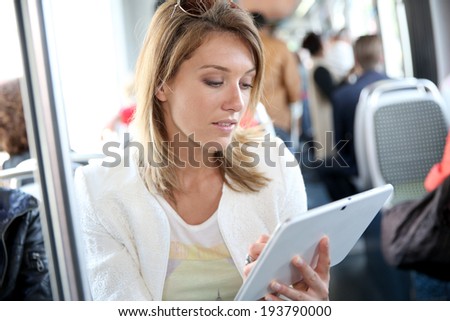 Woman in city train websurfing with tablet
