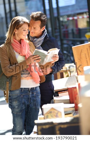 Loving couple walking by book fair on week-end