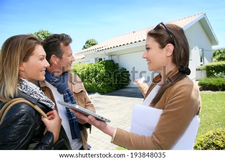 Real-estate agent presenting house to couple