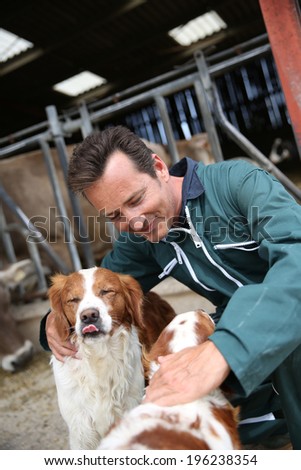 Breeder petting dogs outside the barn