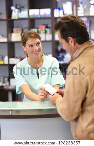 Pharmacist giving advice to customer on medication