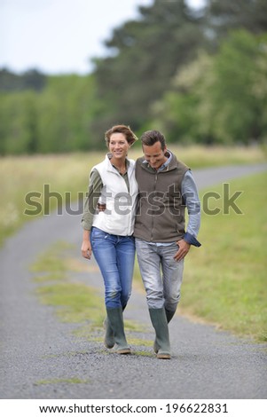 Cheerful 40-year-old couple walking in countryside