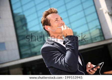 Businessman talking on phone outside building