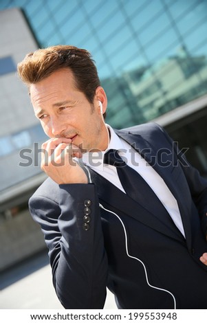 Businessman talking on phone outside building