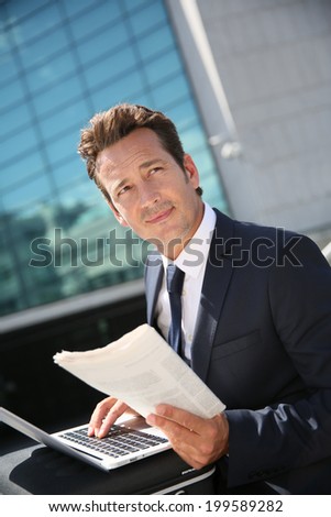 Businessman working on laptop computer outside the office