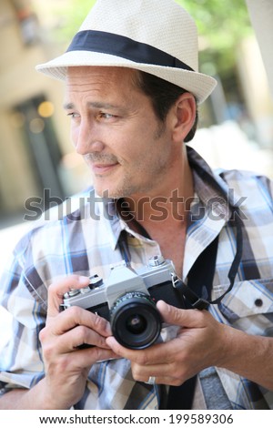 Photographer shooting with vintage camera in town