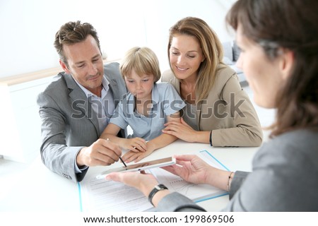 Family signing home purchase contract on tablet