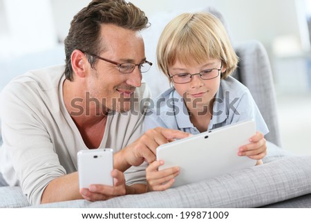 Father and son playing with tablet and smartphone